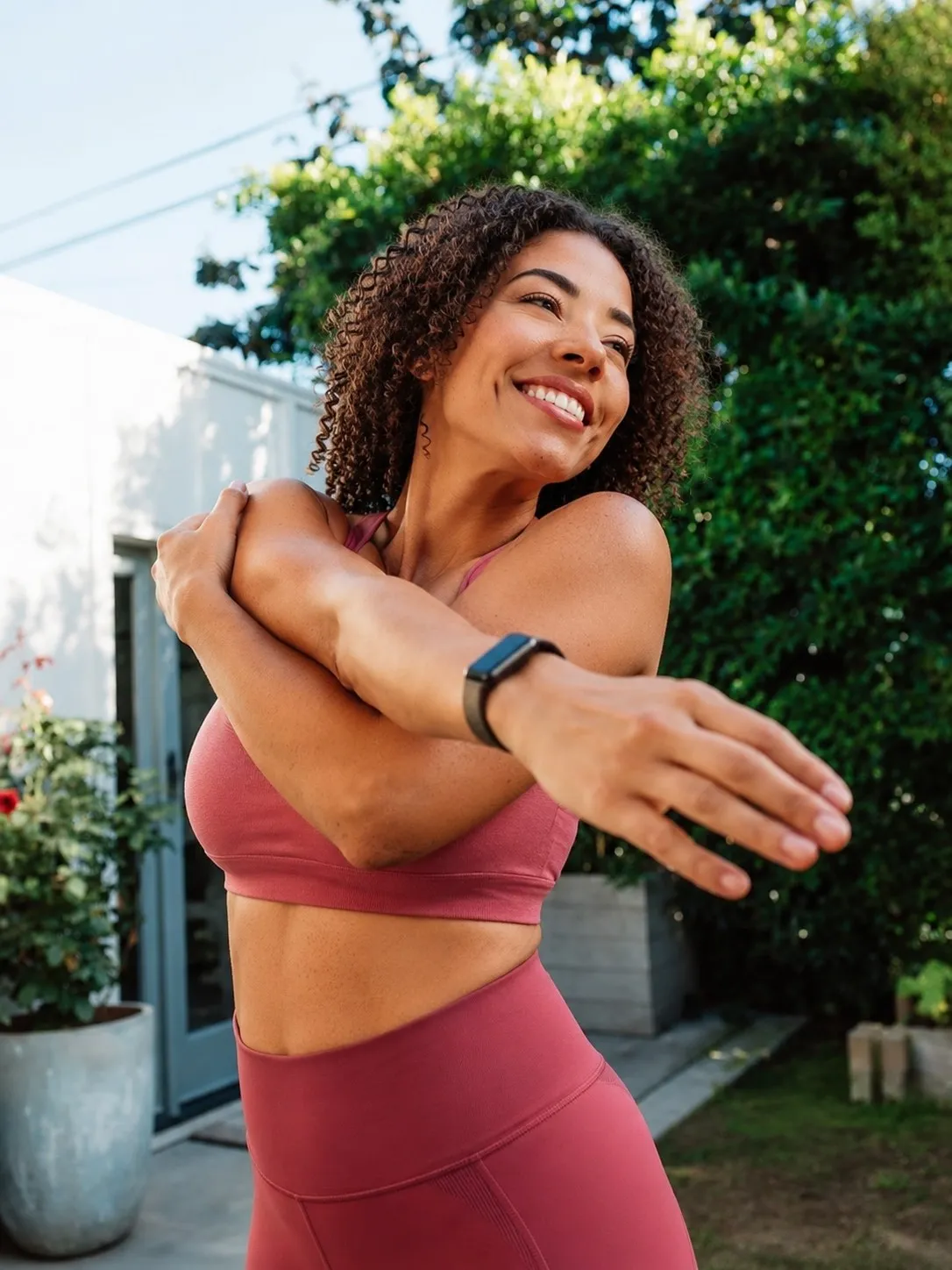 Mulher se alongando ao ar livre com smartwatch